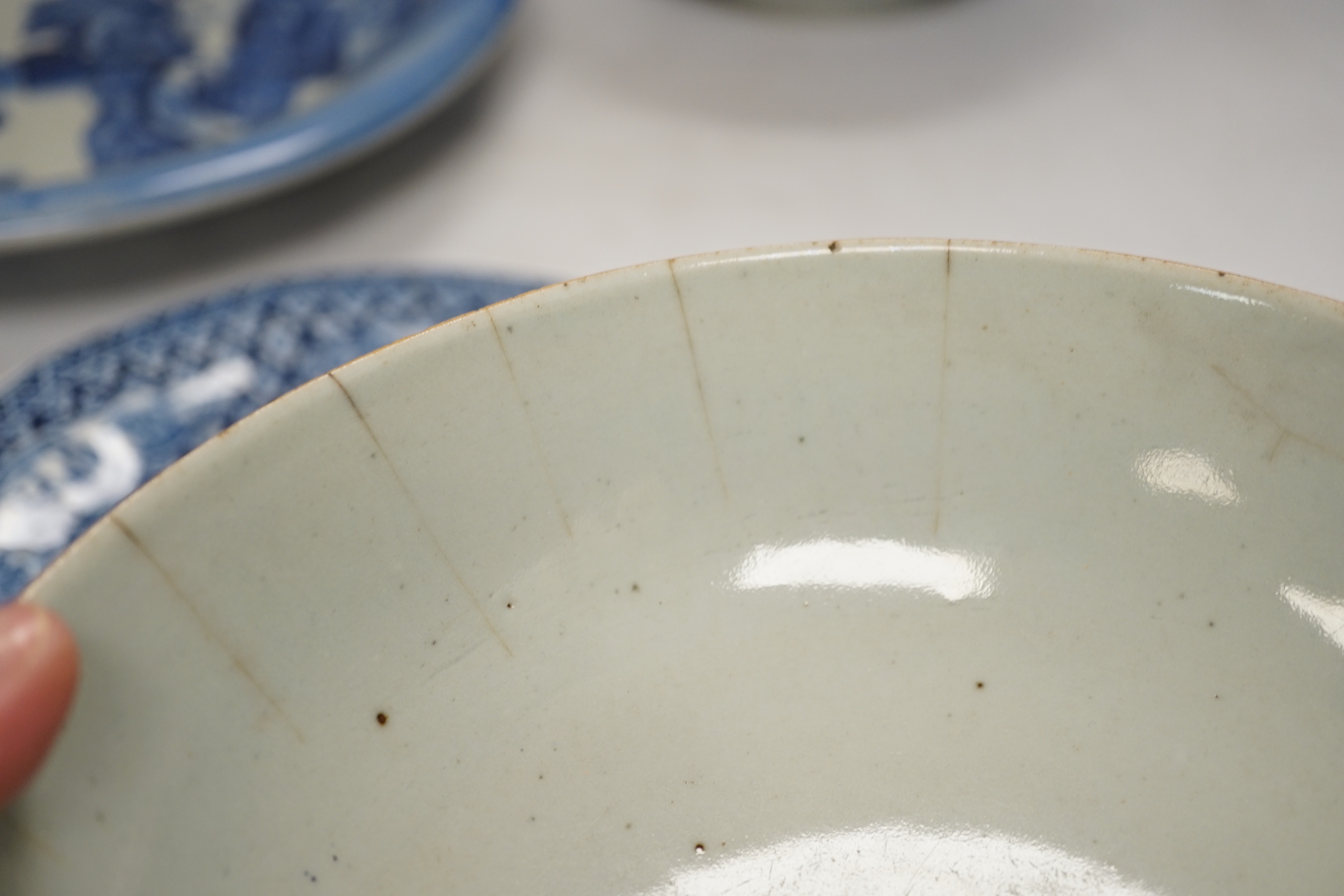 Assorted Chinese and Japanese ceramics comprising a famille rose bowl, two blue and white plates and a blue and white bowl, largest 30cm in diameter